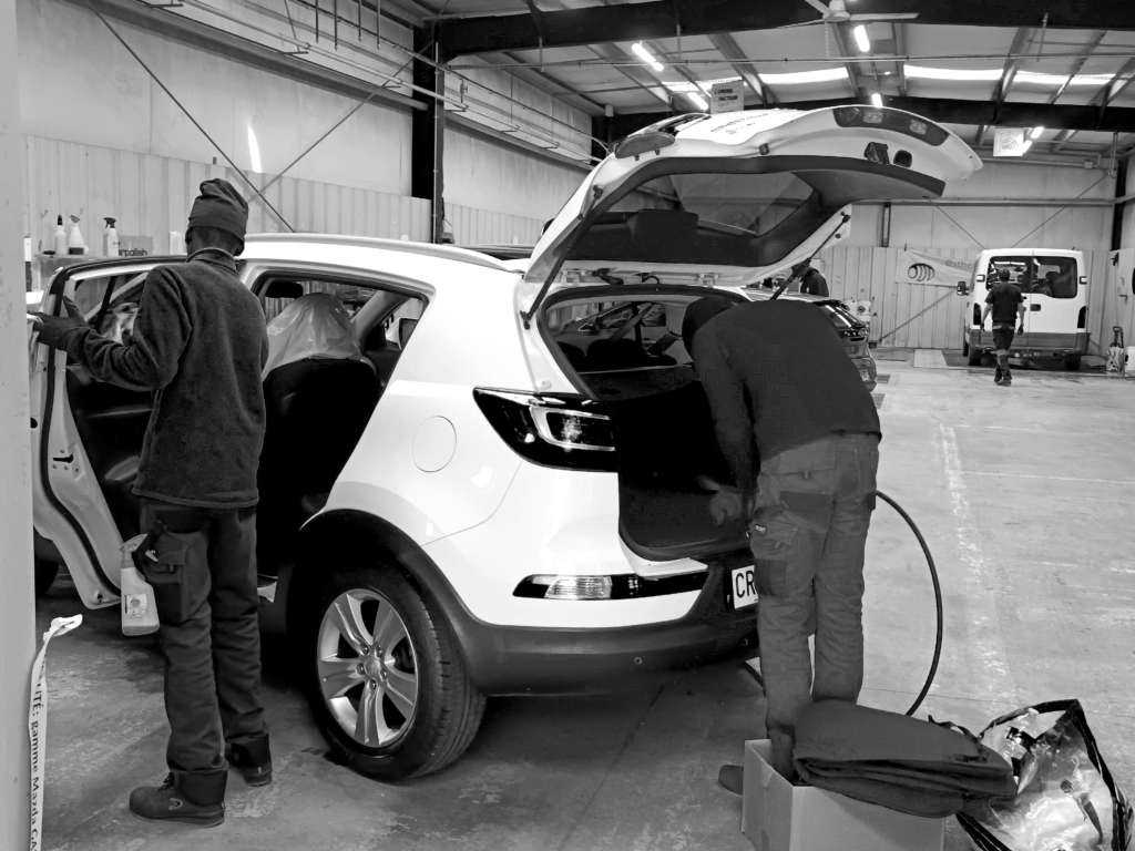 Photo de deux employés qui nettoient une voiture
